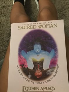 the book sacred woman is sitting on someone's legs