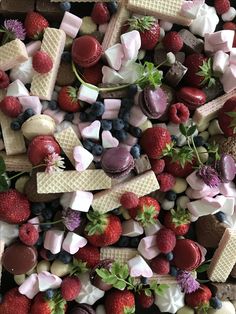 an assortment of desserts are arranged on top of each other, including strawberries and raspberries