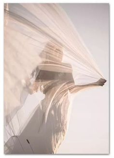 a woman with her hair blowing in the wind, wearing a white dress and holding an umbrella