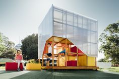 two children are standing outside in front of a house made out of plastic sheeting