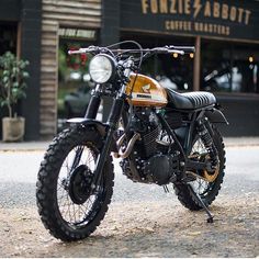 a motorcycle parked on the street in front of a cafe