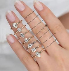 a woman's hand with five different rings on her fingers and one is wearing a ring