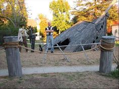 two men standing on top of a wooden structure next to a roped off area