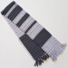 two black and white crocheted scarfs laying next to each other