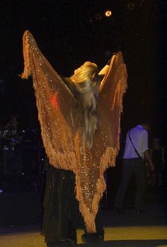 a woman with long blonde hair is performing on stage