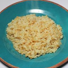 a blue plate topped with rice on top of a table