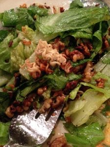 a salad with lettuce and nuts on it