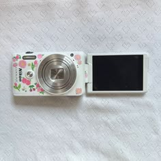 a white camera sitting on top of a bed