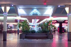 the inside of a mall with fountains and plants