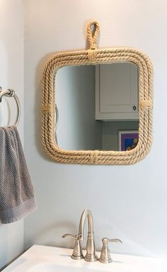 a bathroom sink with a rope mirror hanging on the wall