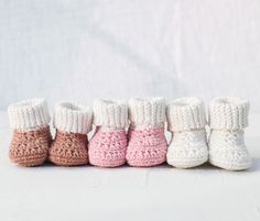 five crocheted baby booties lined up in a row