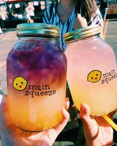 two jars filled with liquid sitting next to each other