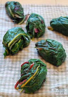 spinach leaves with red peppers and green onions on a tableclothed cloth, ready to be cooked