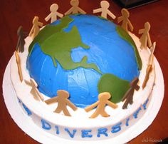 a cake decorated with people holding hands around the world