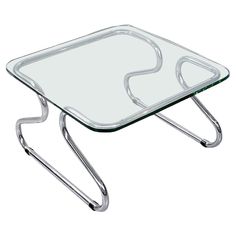 a glass coffee table with metal legs and a square shaped design on the top is shown