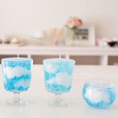 three blue and white candles sitting on top of a table next to eachother