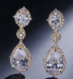 two pairs of diamond earrings are shown on a black surface