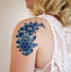 a woman's shoulder with blue flowers on the back of her left arm and right arm