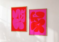 two red and pink paintings hanging on the wall