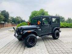 a black jeep parked on top of a brick road