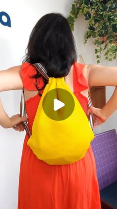 a woman in an orange dress with a yellow purse on her back, and the video below