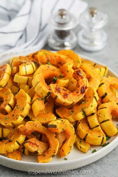 roasted squash on a white plate with parsley sprinkled around the edges, ready to be eaten