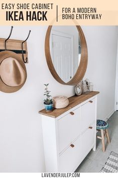 a white dresser sitting next to a wall with a clock on it and a mirror above it