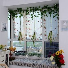 the window is decorated with flowers and greenery on it's windowsills