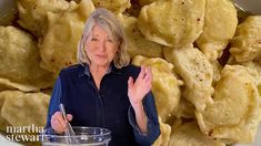 a woman standing in front of a bowl filled with dumplings