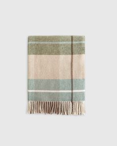 a tan and green plaid blanket with fringes