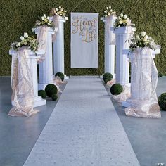 an aisle decorated with white flowers and greenery