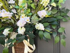 a basket filled with lots of flowers sitting on top of a door