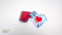 two heart shaped candy boxes sitting next to each other on top of a white surface