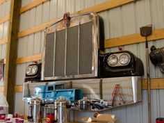 an old truck is sitting on top of a shelf in a garage with other items