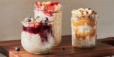 three jars filled with different types of food on top of a wooden table next to each other