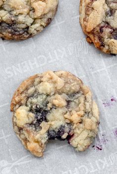 three cookies with crumbs on top of paper