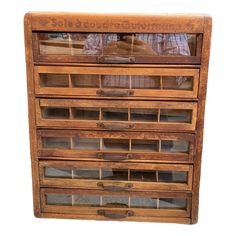 an old wooden drawer with many drawers on it's sides and some glass inserts in the bottom