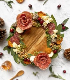 a wreath made out of meats, cheese and leaves on top of a table