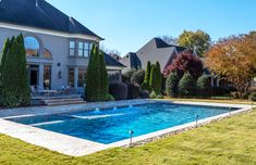 a large house with a pool in the front yard and lawn area next to it