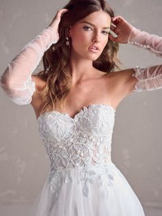 a woman in a wedding dress is posing for the camera with her hands on her head