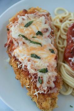 two pieces of chicken parmesan and pasta on a plate