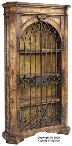 an old wooden bookcase with wrought iron doors