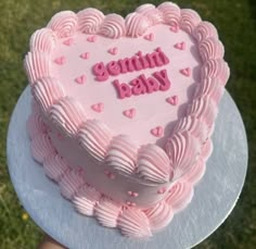 a heart shaped cake with pink frosting on top