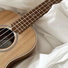 an ukulele is laying on a white sheet