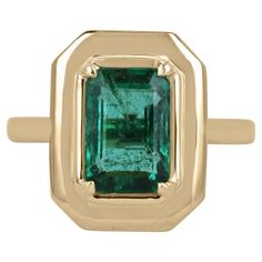 a gold ring with an emerald stone in the center