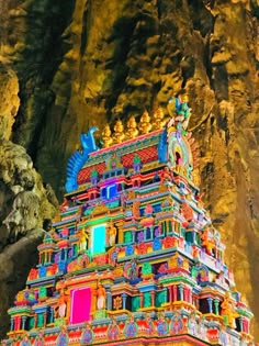 an elaborately decorated temple in the middle of a mountain side area with large rocks on both sides