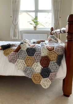 a crocheted blanket is on top of a bed in front of a window