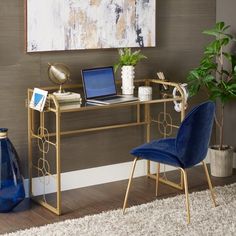 a desk with a laptop on it next to a blue chair and potted plant