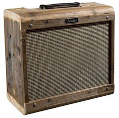 an old style guitar amplifier sitting on top of a wooden box with the word fender written on it