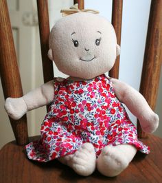 a stuffed doll sitting on top of a wooden chair